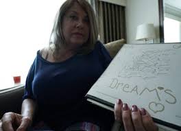 Heidi Hutchinson  holds the "Dream Chart  of her late sister Gina Hutchinson.