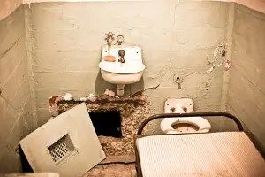 Prison cell in Alcatraz witha hole in the wall, San Francisco. Grainy due to high iso level.