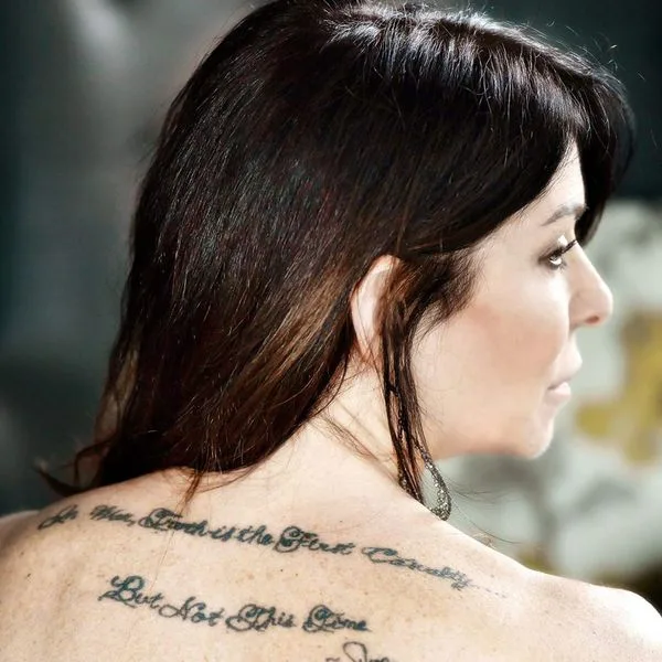Toni Natalie has a tattoo on her back that says "Truth is the first casualty of war, but not this time." 
She claims she got this tattoo in honor of her brother who she says committed suicide because of Keith Raniere. 
Her brother did not commit suicide.