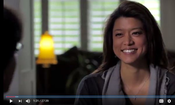 Grace Park in a promotional video with Keith Alan Raniere. Robyn advises Frank Report not to mention her name because her husband might get mad and do something violent.