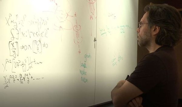 So brilliant. Keith Alan Raniere looks over his genius calculations.