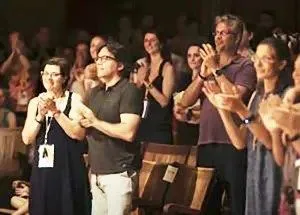 Keith Raniere with his followers including Clare Bronfman applaud a performance on Raniere's birthday