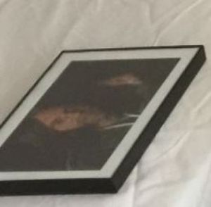 A discarded picture of worshipful Keith Raniere. Left on an empty mattress at Silver Bay. It was once venerated and hung on walls during V-Week in devotees rooms.