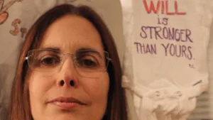 Talk about super-creepy. The late Pamela Cafritz poses next to a baby outfit - that seems to sum up the philosophy of Raniere. At the shower, apparently the women had stencils and pens and printed messages on the baby outfits.