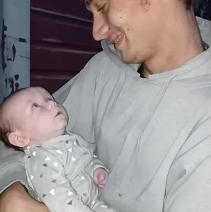 Daniel Williams with his child in his arms.