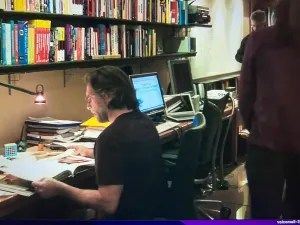 Raniere at his desk in his library where the hard drive and camera were seized.