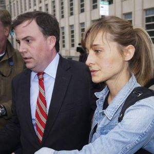 Sean Buckley, attorney for Allison Mack, leads her out of court and past reporters, after she made bail after spending several days in jail.