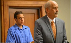 Indicted for child pornography, Jasun Sulla stands behind his lawyer father, Paul Sulla.