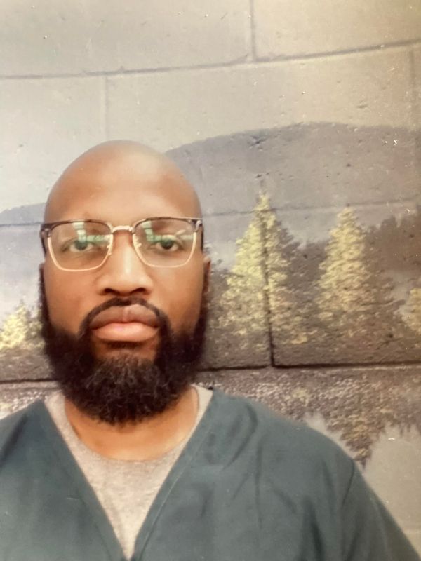 Lawrence Paine from a photo taken in prison with a background of trees and hills he has not seen in 19 years.