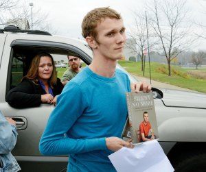 Aaron Fisher holding the book he co-wrote about his repressed memory therapy with his therapist Mike Gillum.