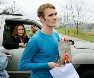 Aaron Fisher holding the book he co-wrote about his repressed memory therapy with his therapist Mike Gillum.