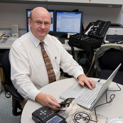 Computer Forensics expert Stephen Bunting, Public Safety works to extract information on a cell phone for analysis.